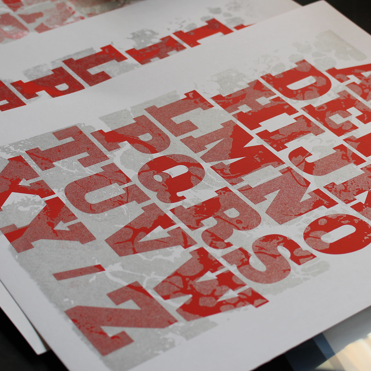 gros plan de l'abécédaire imprimé en sérigraphie rouge et argenté à l'atelier fwells